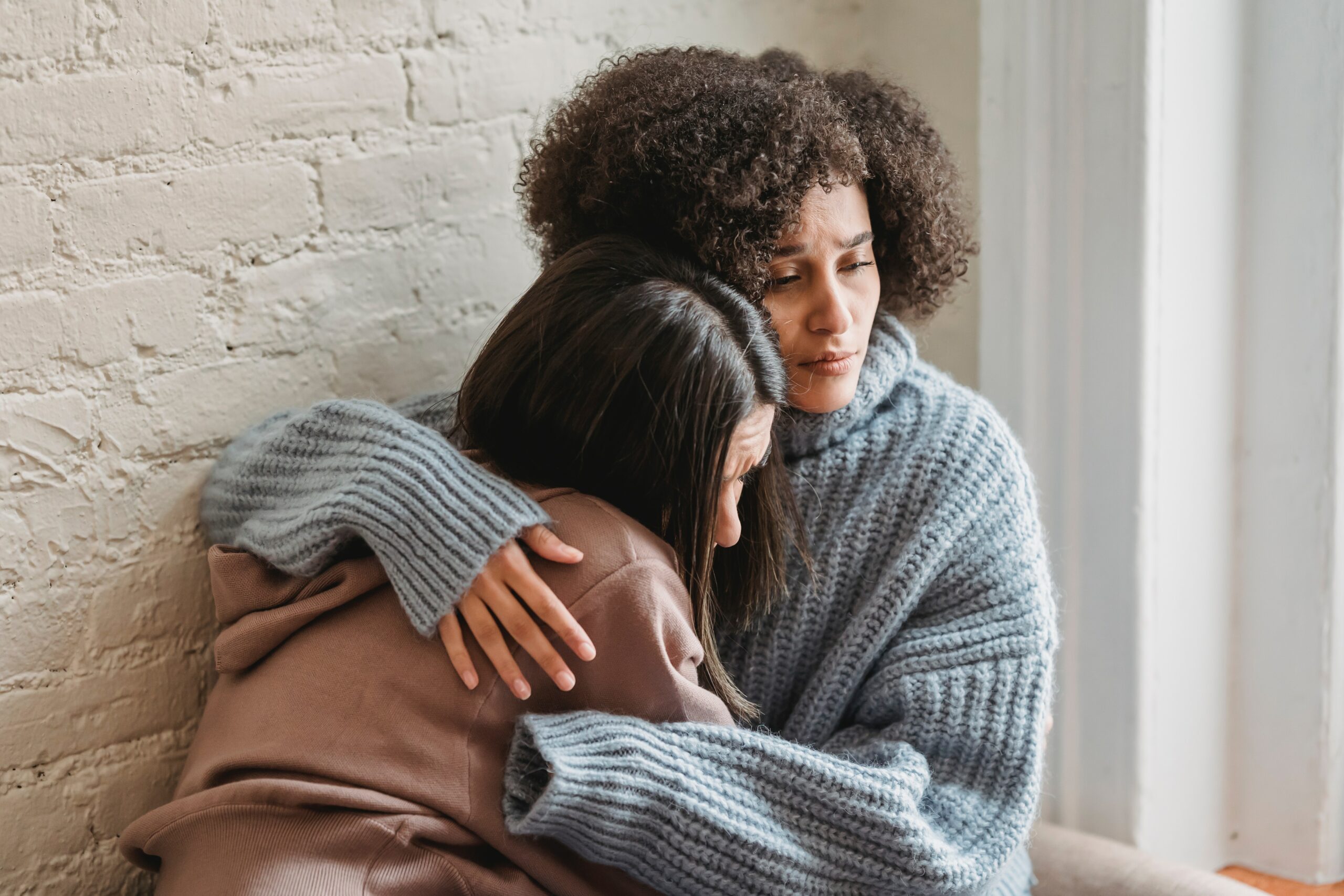 friend hugging sad friend